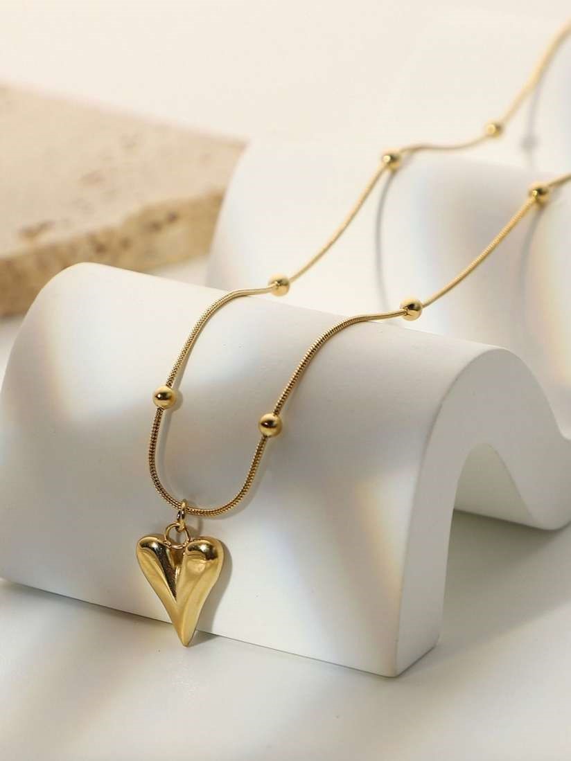 "A delicate gold-toned heart pendant necklace with smooth finish, perfect for romantic and everyday wear."
